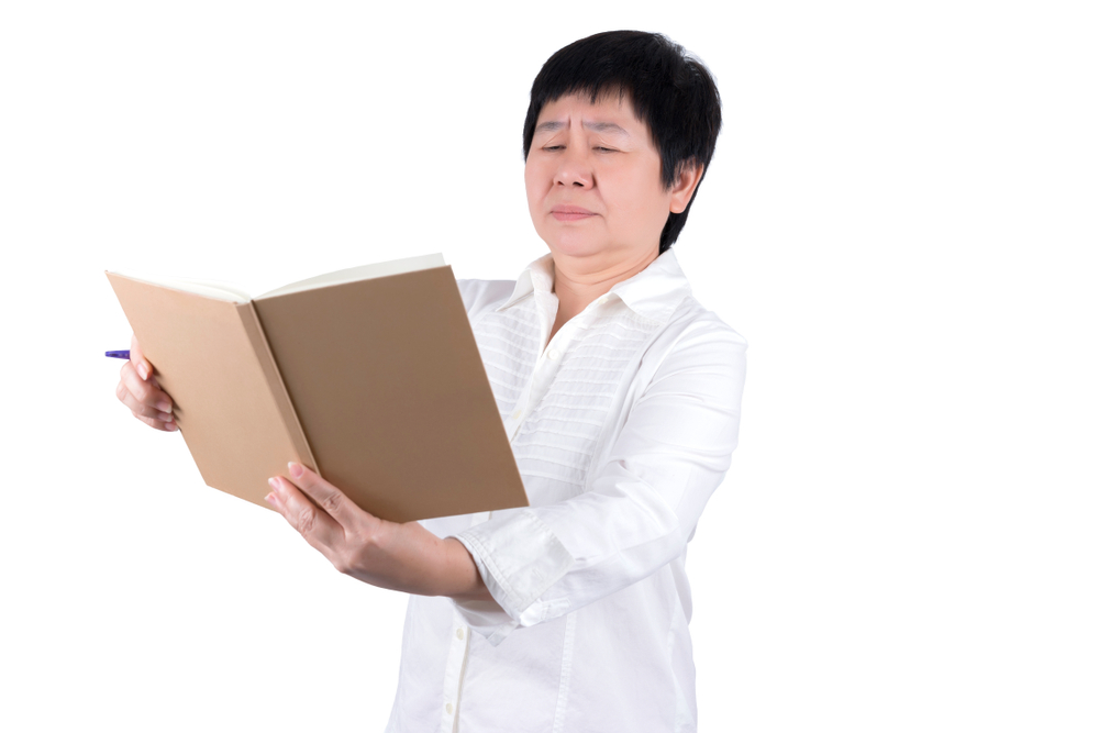 woman reading a book without glasses